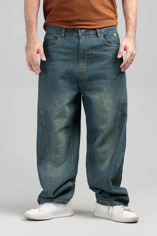 Person wearing blue jeans and a brown shirt on a gray background