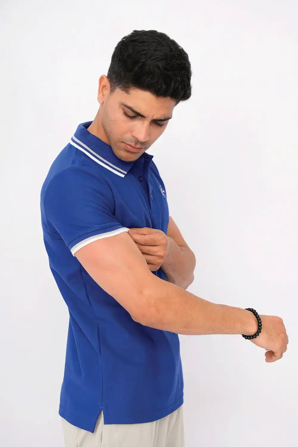 Blue polo shirt with white trim on a white background