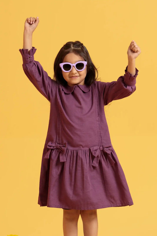 Child wearing a purple dress and pink sunglasses