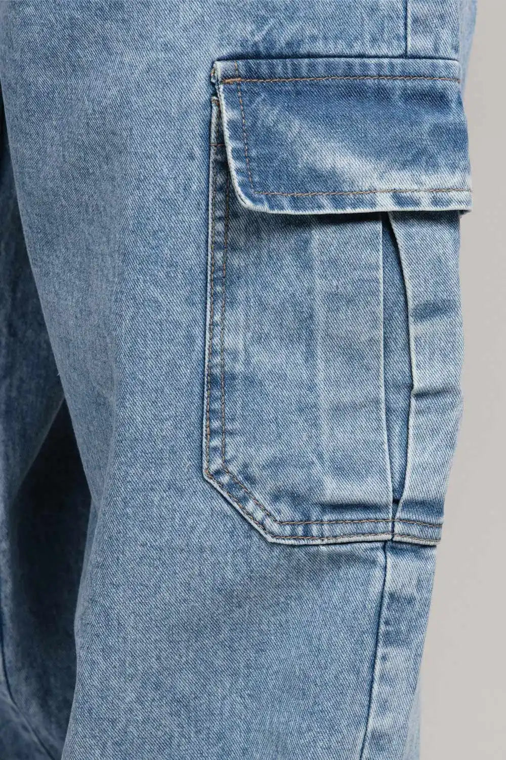 Close-up of a blue denim pocket on a gray background