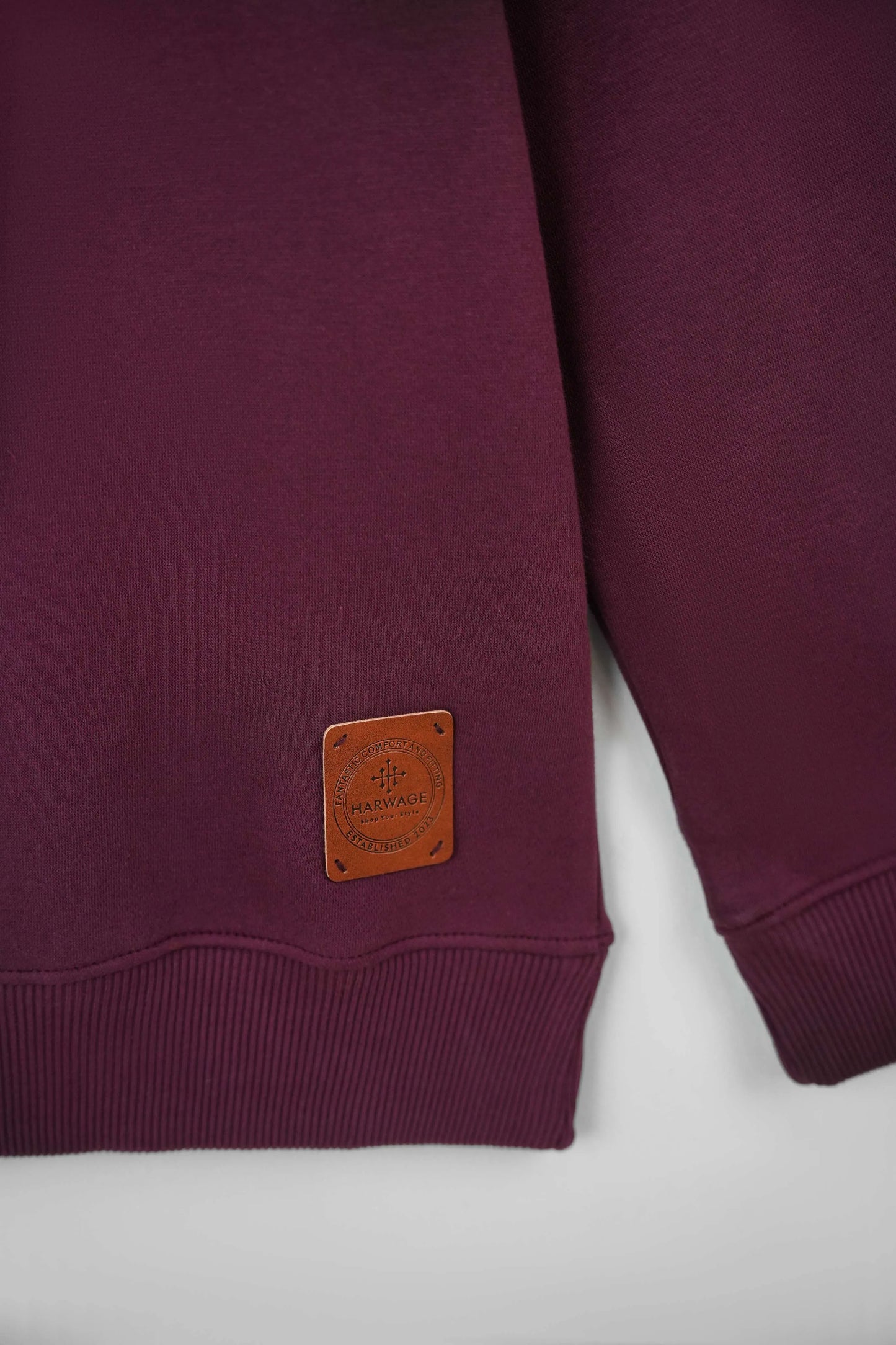 Maroon sweatshirt with a brown leather patch on a white background