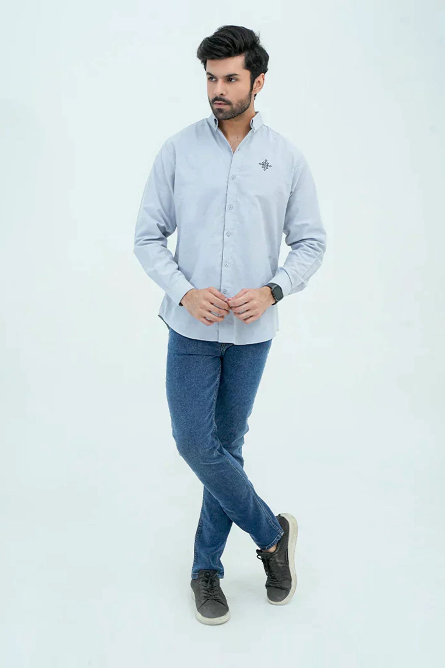 Man wearing light blue Oxford shirt with jeans
