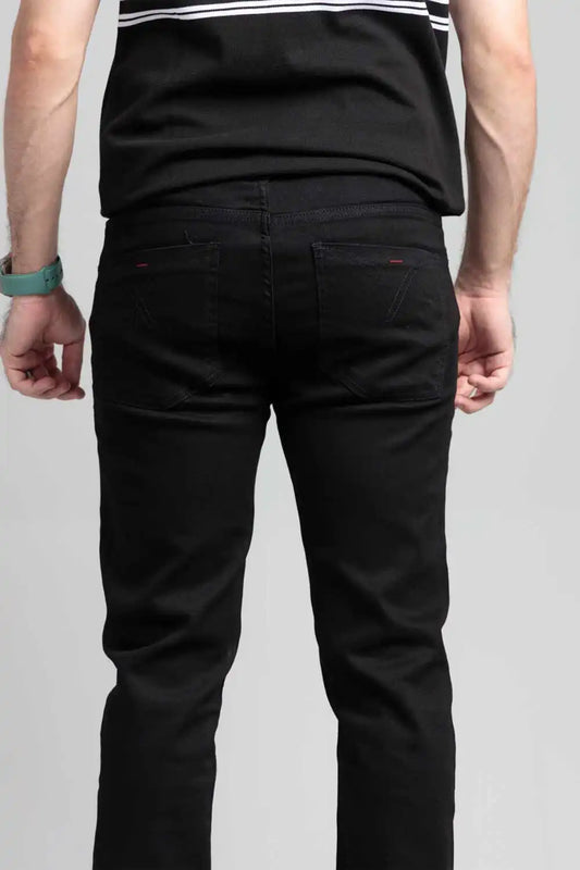 Person wearing black pants on a plain background