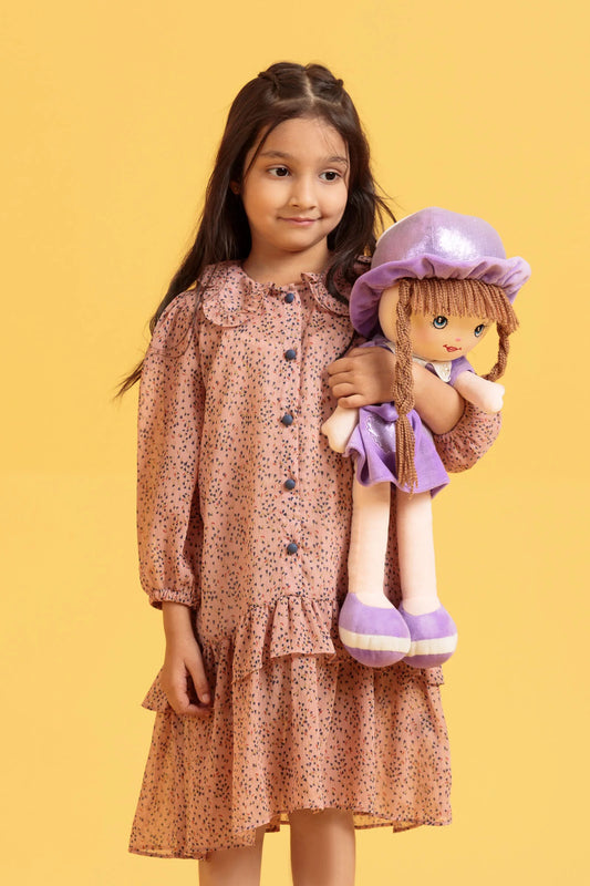Young girl holding a doll against a yellow background