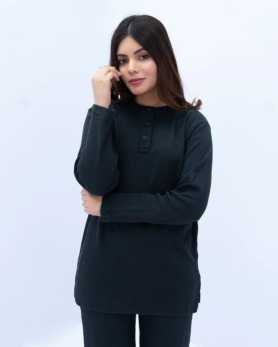 A woman wearing a black long-sleeve top 