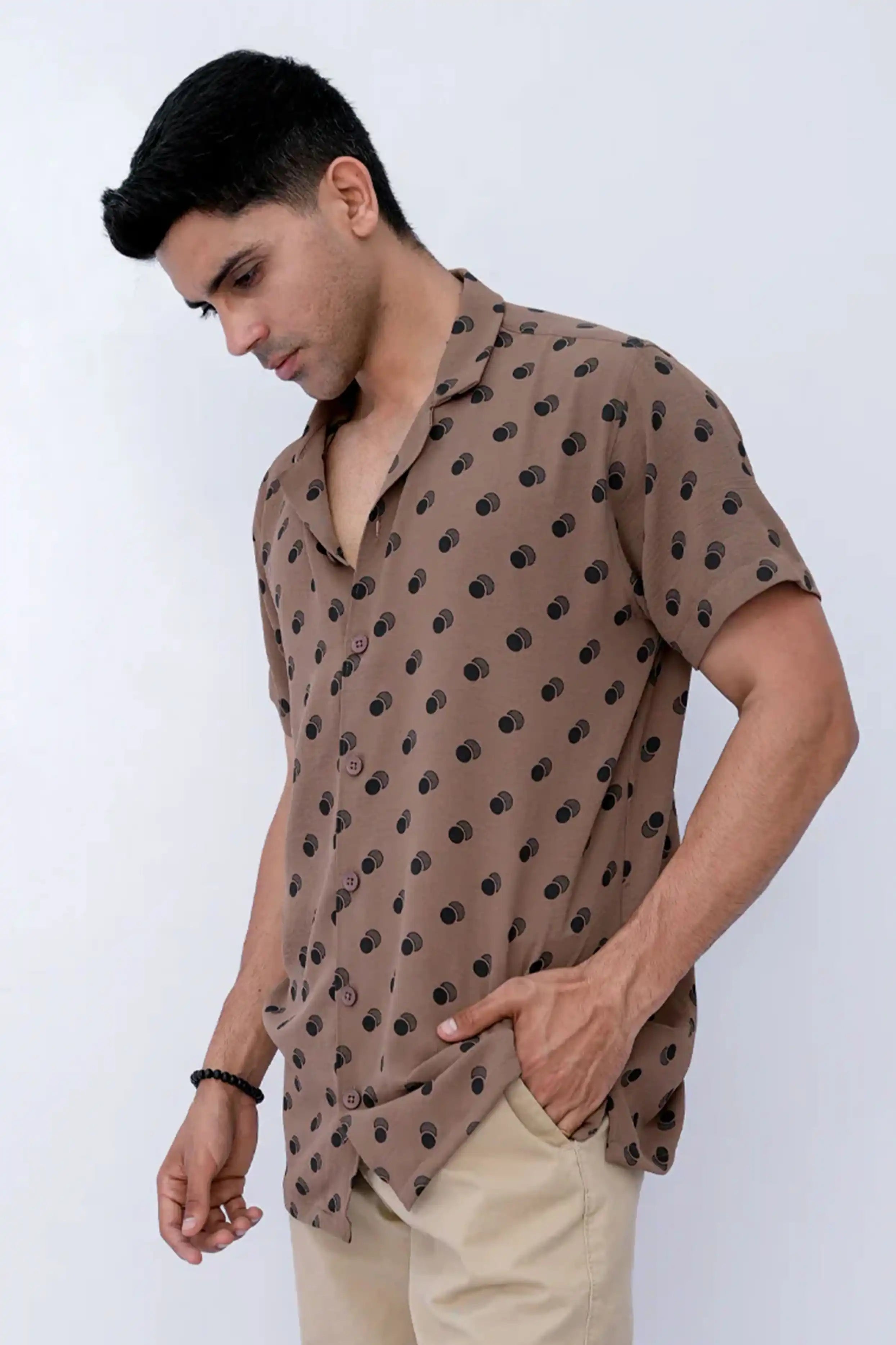 A boy wearing a brown patterned shirt  