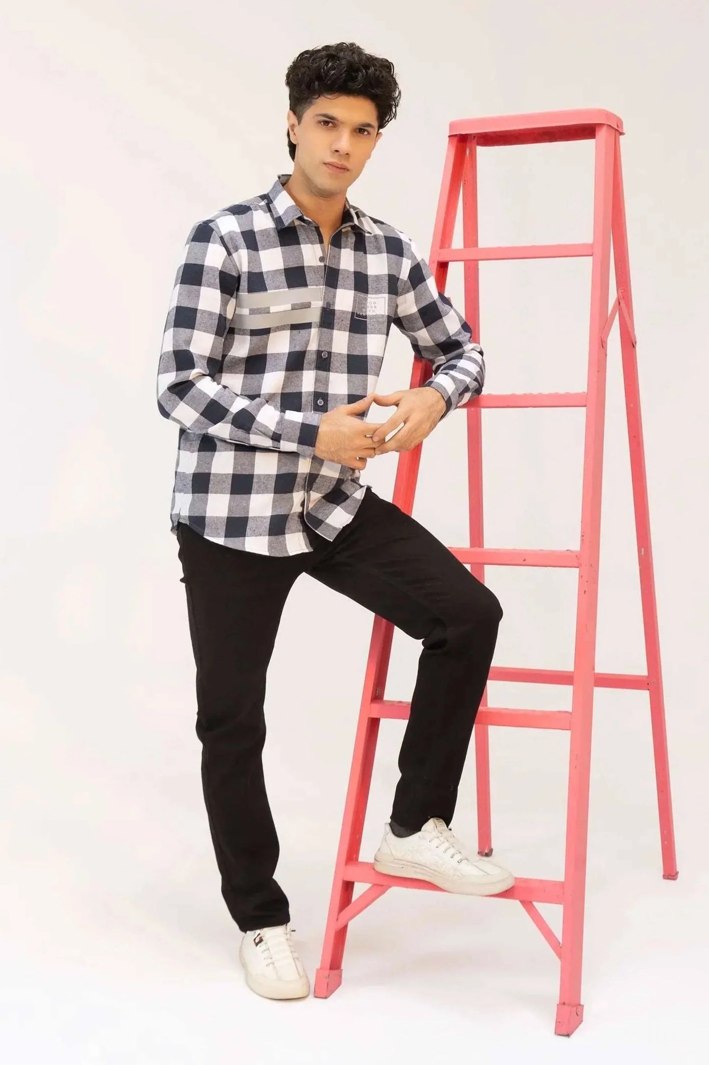 A man dressed in a black and white checkered shirt and black jeans