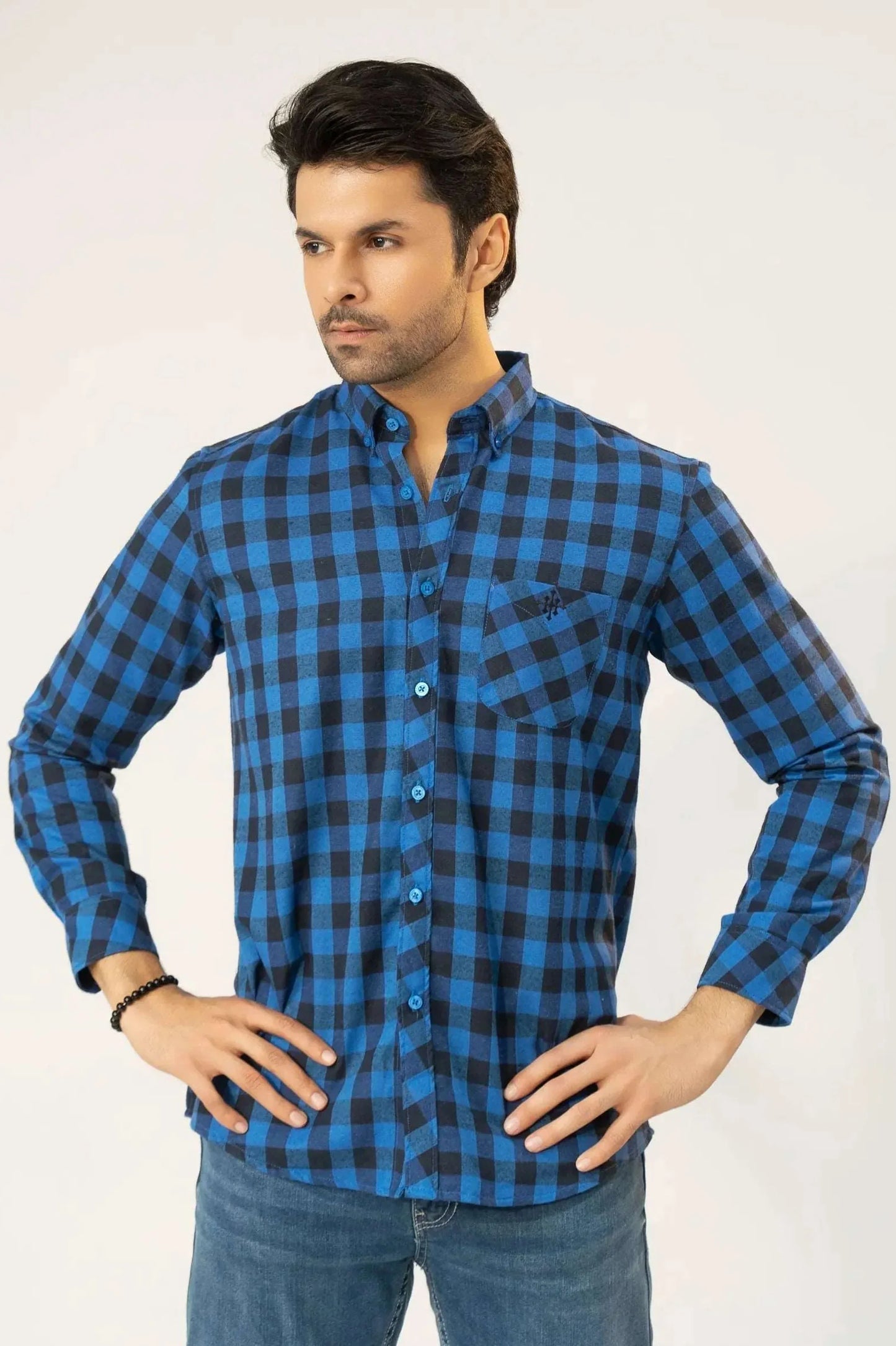 A man dressed in a blue and black checkered shirt and jeans