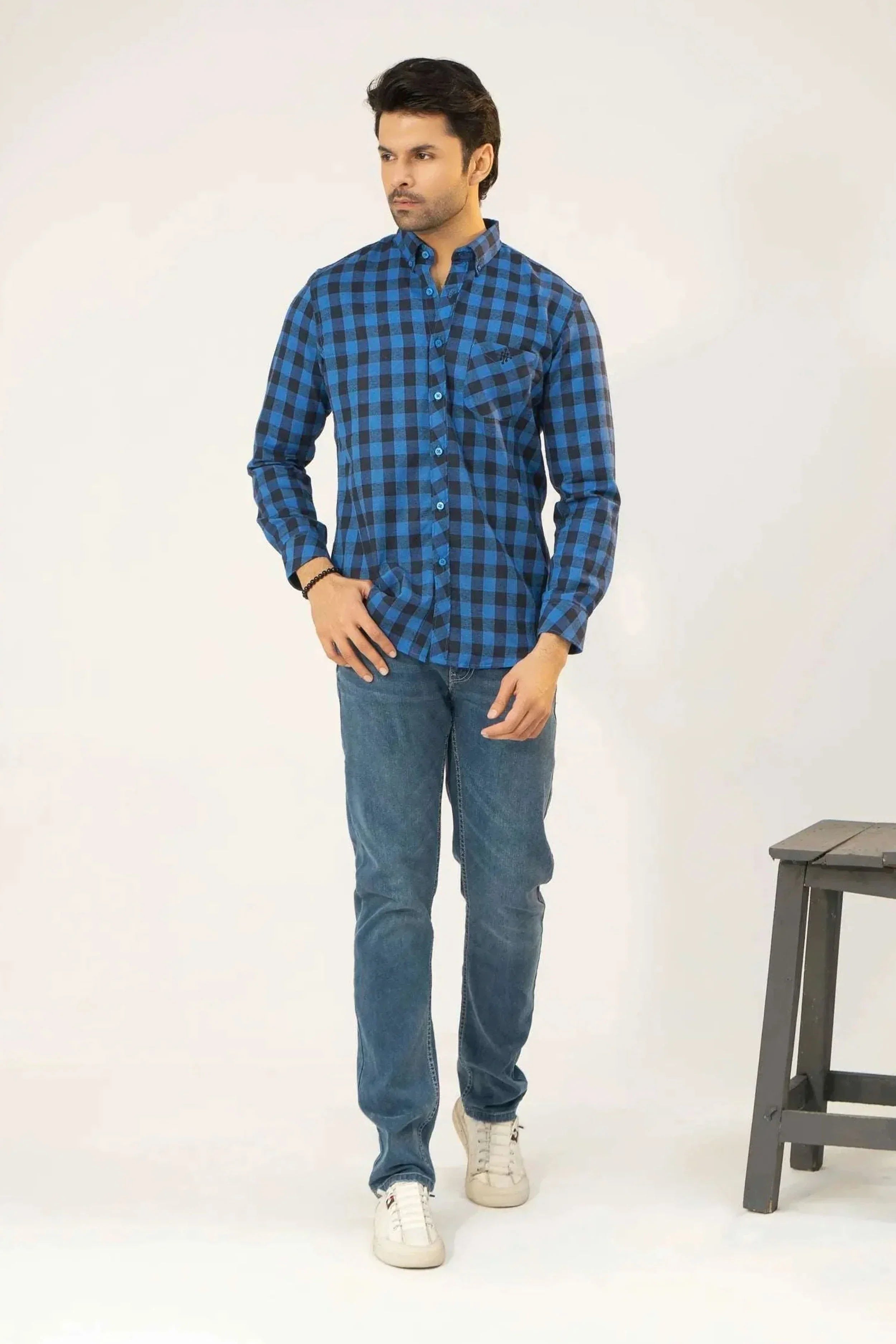 A man dressed in a blue checkered shirt and jeans