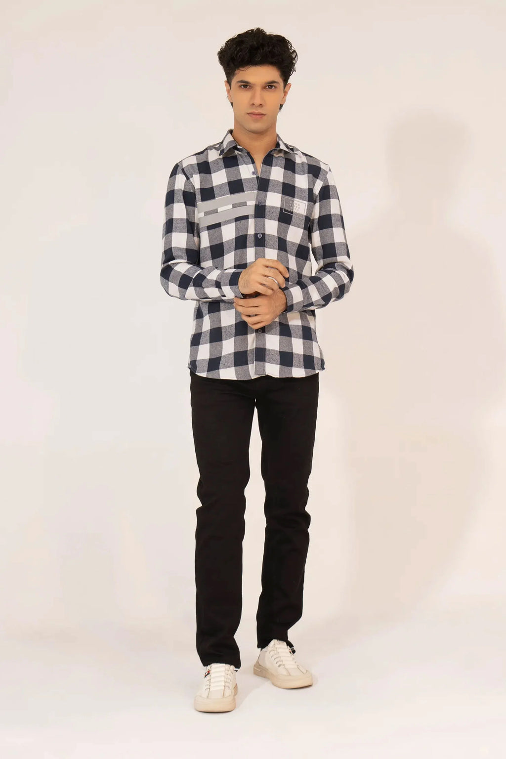 A man wearing a black and white checkered shirt and black pants