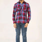 A man wearing a red and blue plaid shirt with jeans