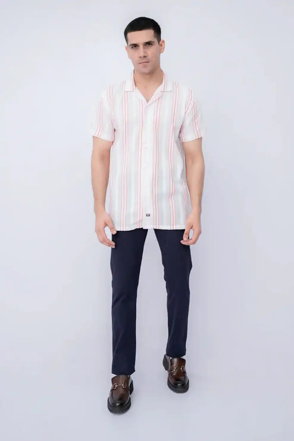 A man wearing a striped shirt and dark pants