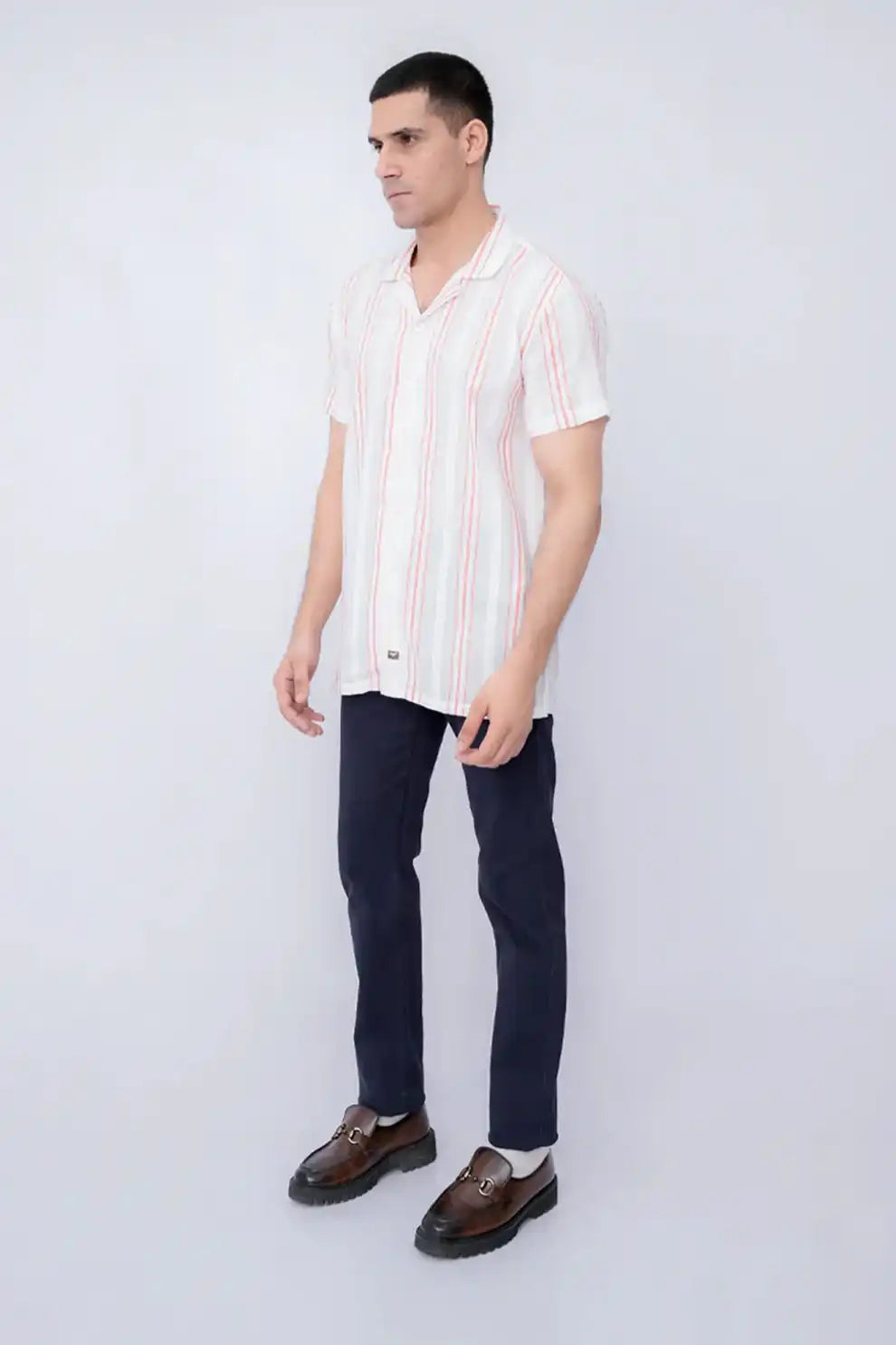 A man wearing a striped shirt with dark pants