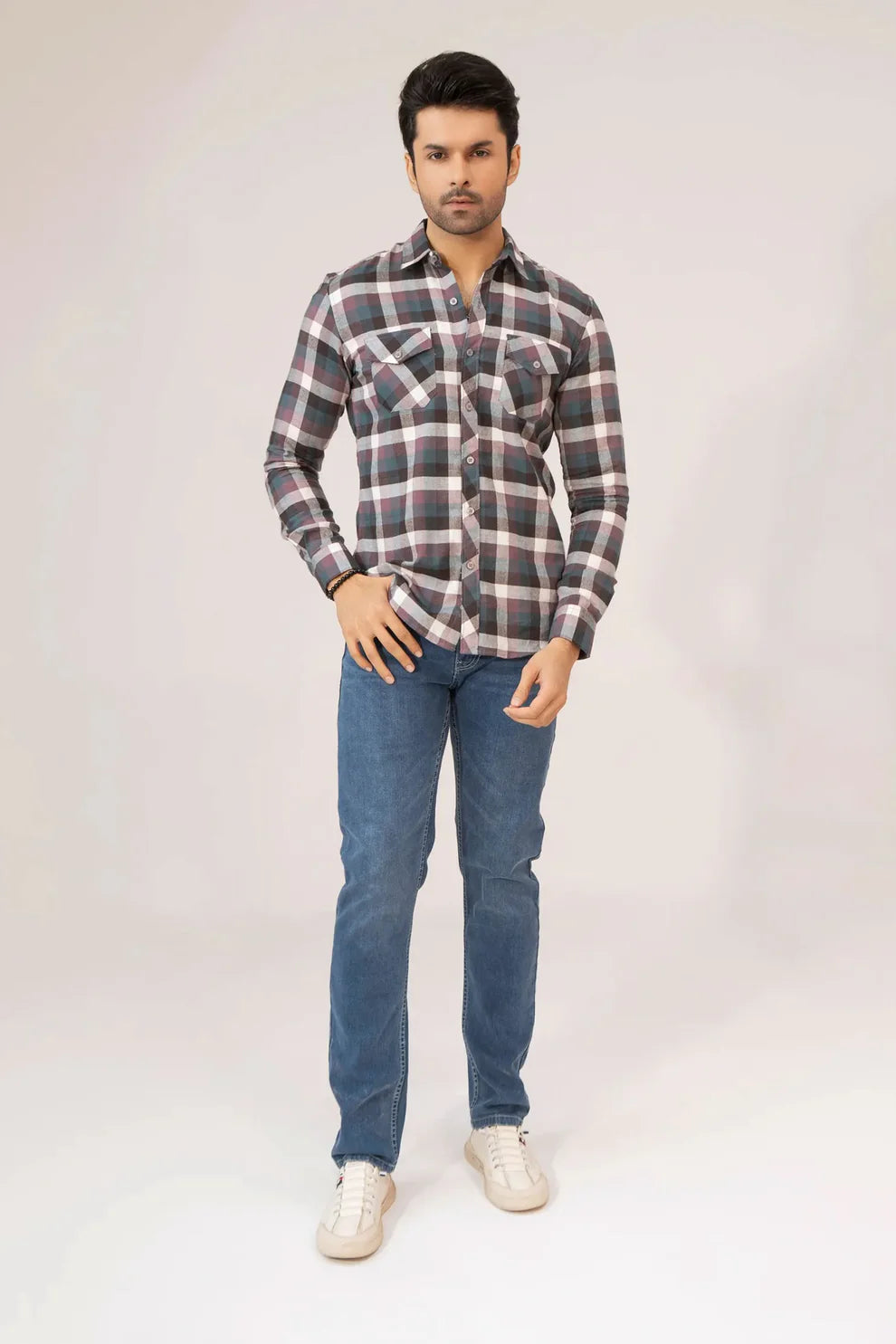 A man wearing a stylish shirt and jeans 