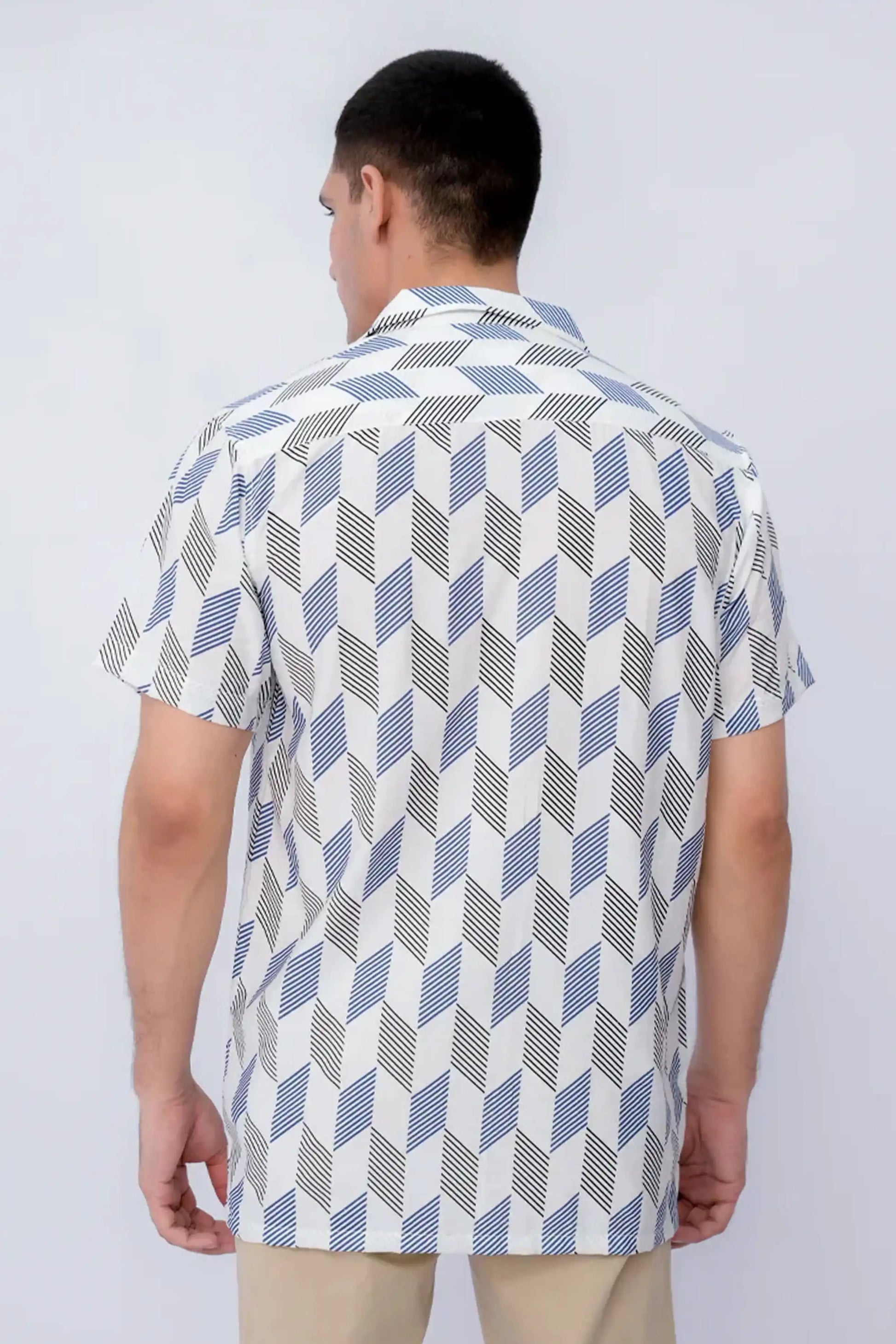 A man wearing a patterned shirt with a white background