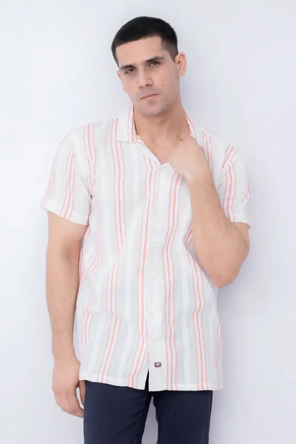A man wearing a white shirt with red stripes