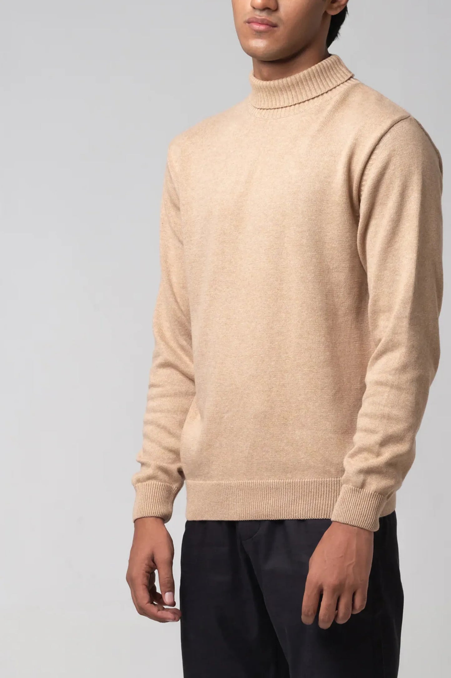 Angled full body view highlighting turtle neck sweater beige