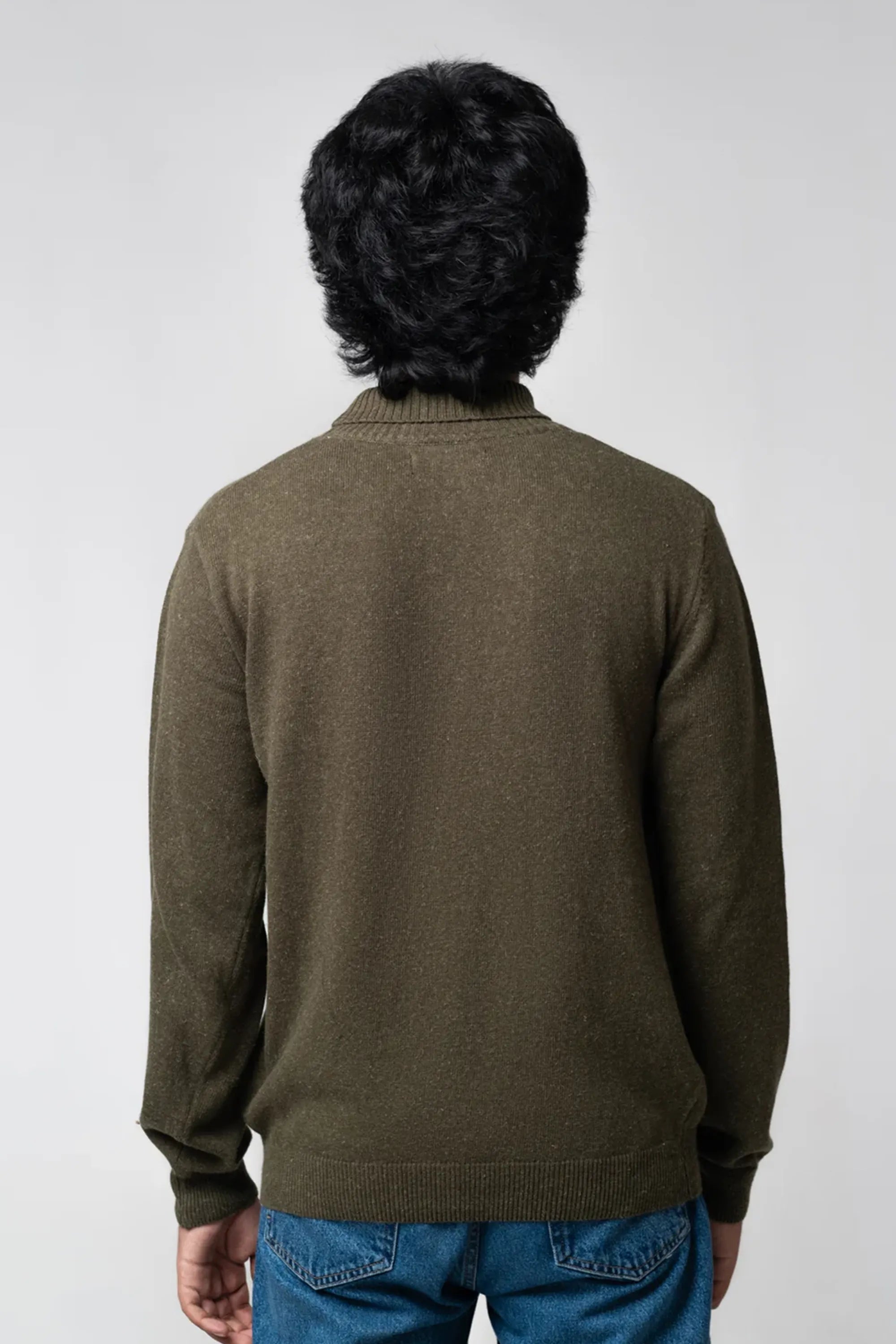 Back standing view of turtle neck sweater olive showing relaxed fit
