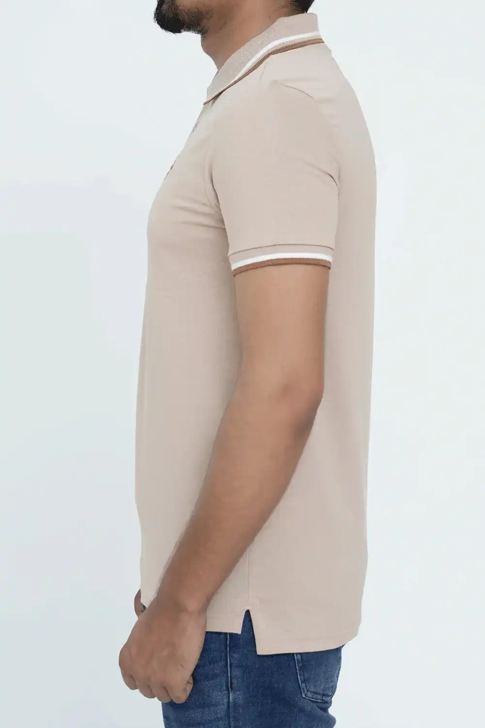 Man wearing a beige polo shirt with white trim on a light gray background