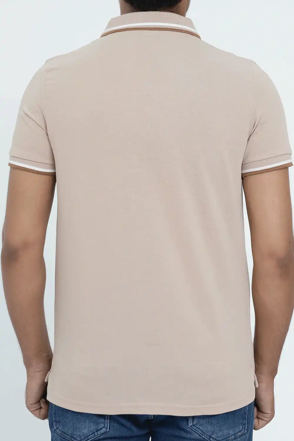 Beige polo shirt worn by a person on a light gray background