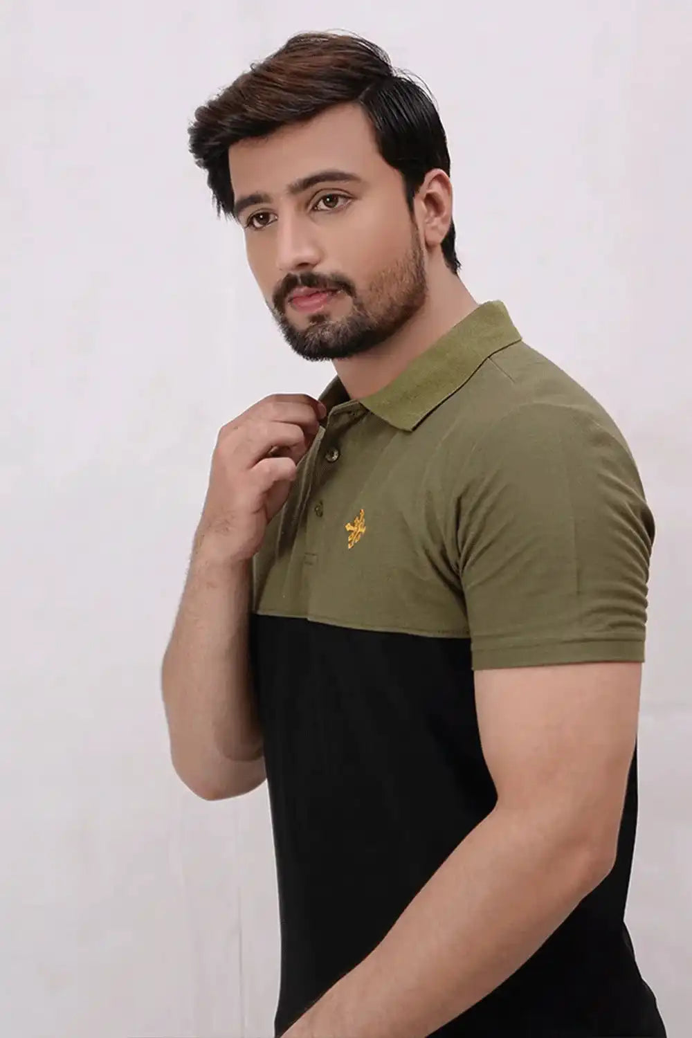 A man wearing a black and green polo shirt with a logo