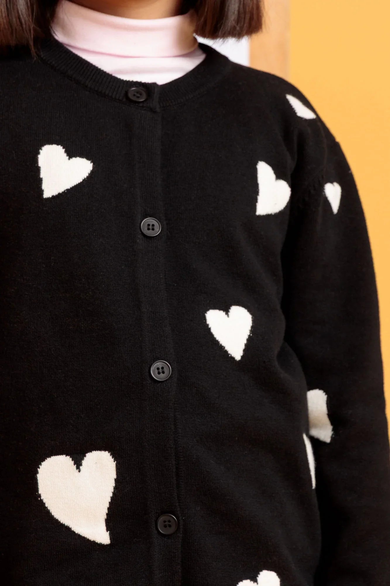 Black cardigan with white heart patterns