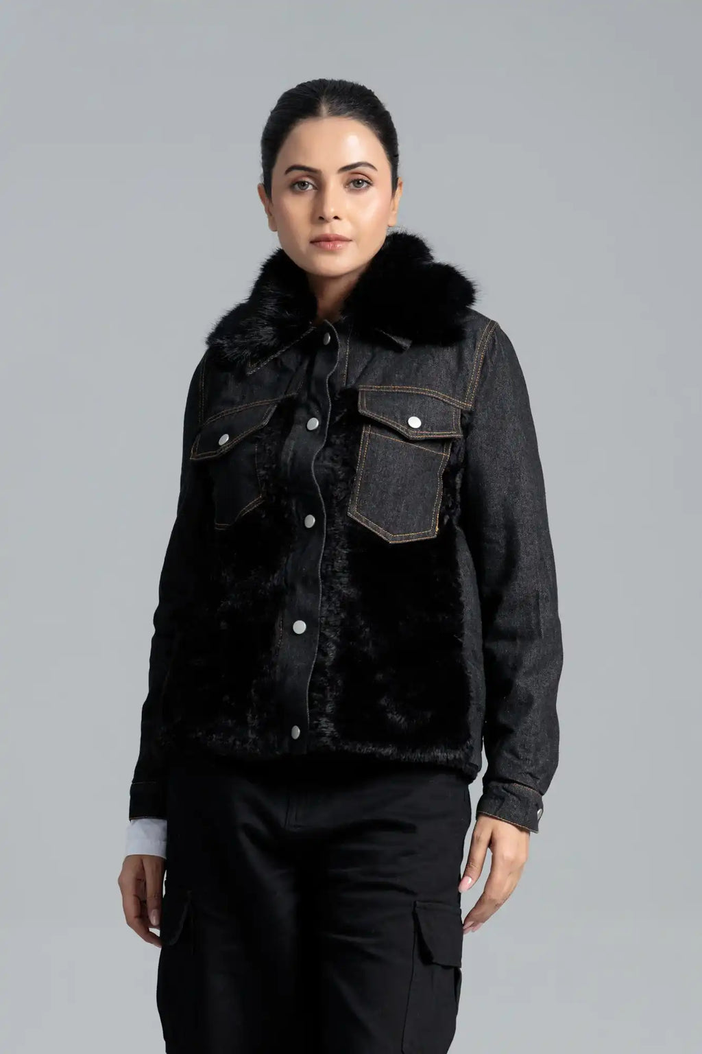 Woman wearing a black denim jacket with fur trim 