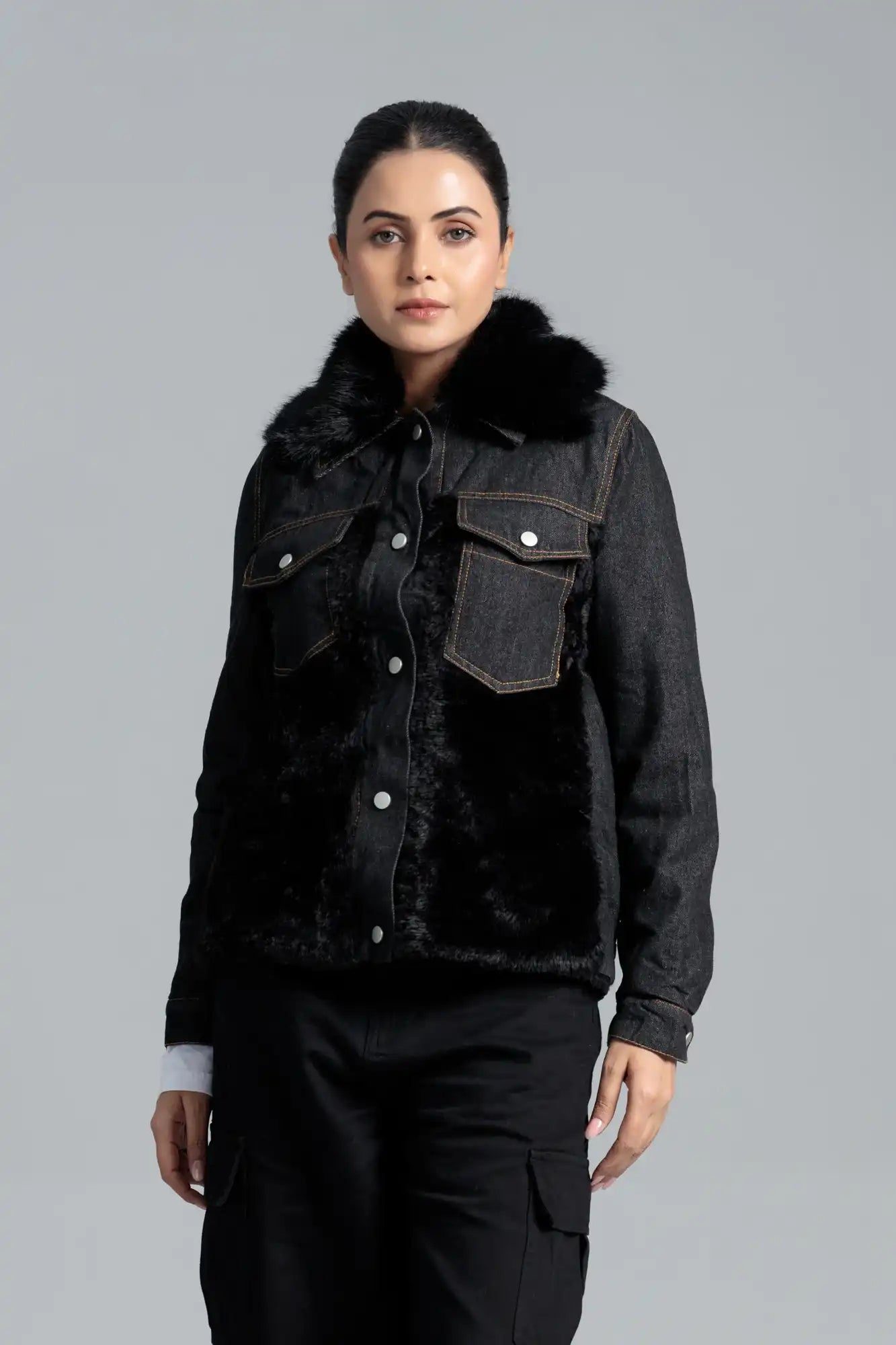 Woman wearing a black denim jacket with fur trim 