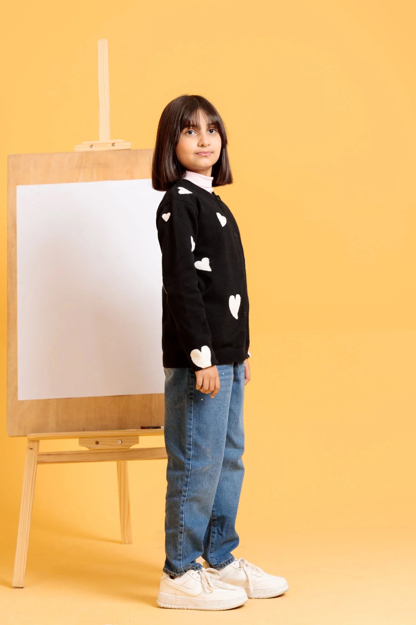 Child wearing a black sweater with white heart patterns