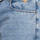 Close-up of blue denim jeans with an eagle logo on the pocket