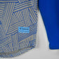 Blue geometric-patterned shirt with a visible brand label 