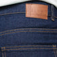 Close-up of blue jeans with a visible brand label on the pocket.