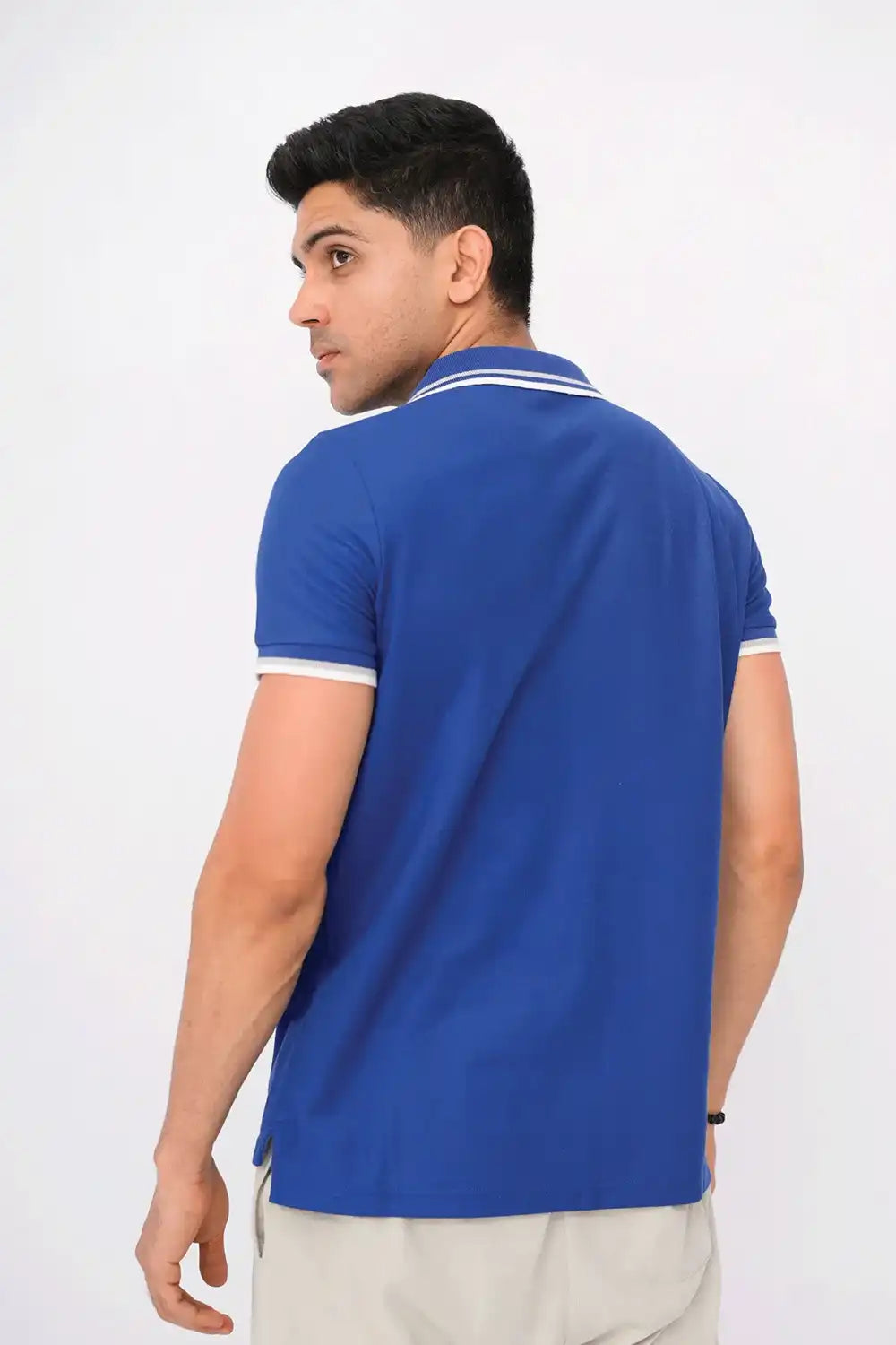 A man wearing a blue polo shirt with a white logo