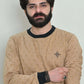 Casual crossed-arm pose wearing a beige sweatshirt with palm motifs