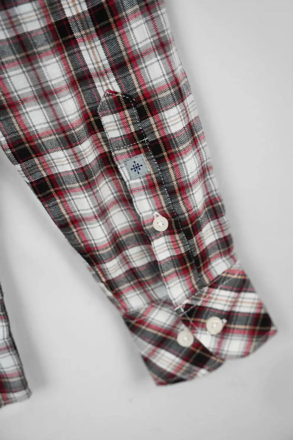 Checkered shirt cuff close-up with button fastening