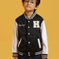 Child model posing in a Baseball Jacket in Black with white sleeves