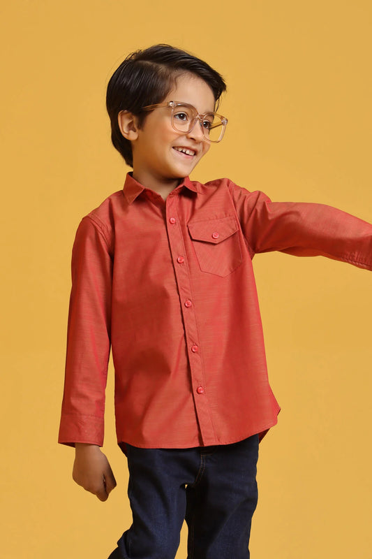 Child wearing a red shirt and glasses on a yellow background