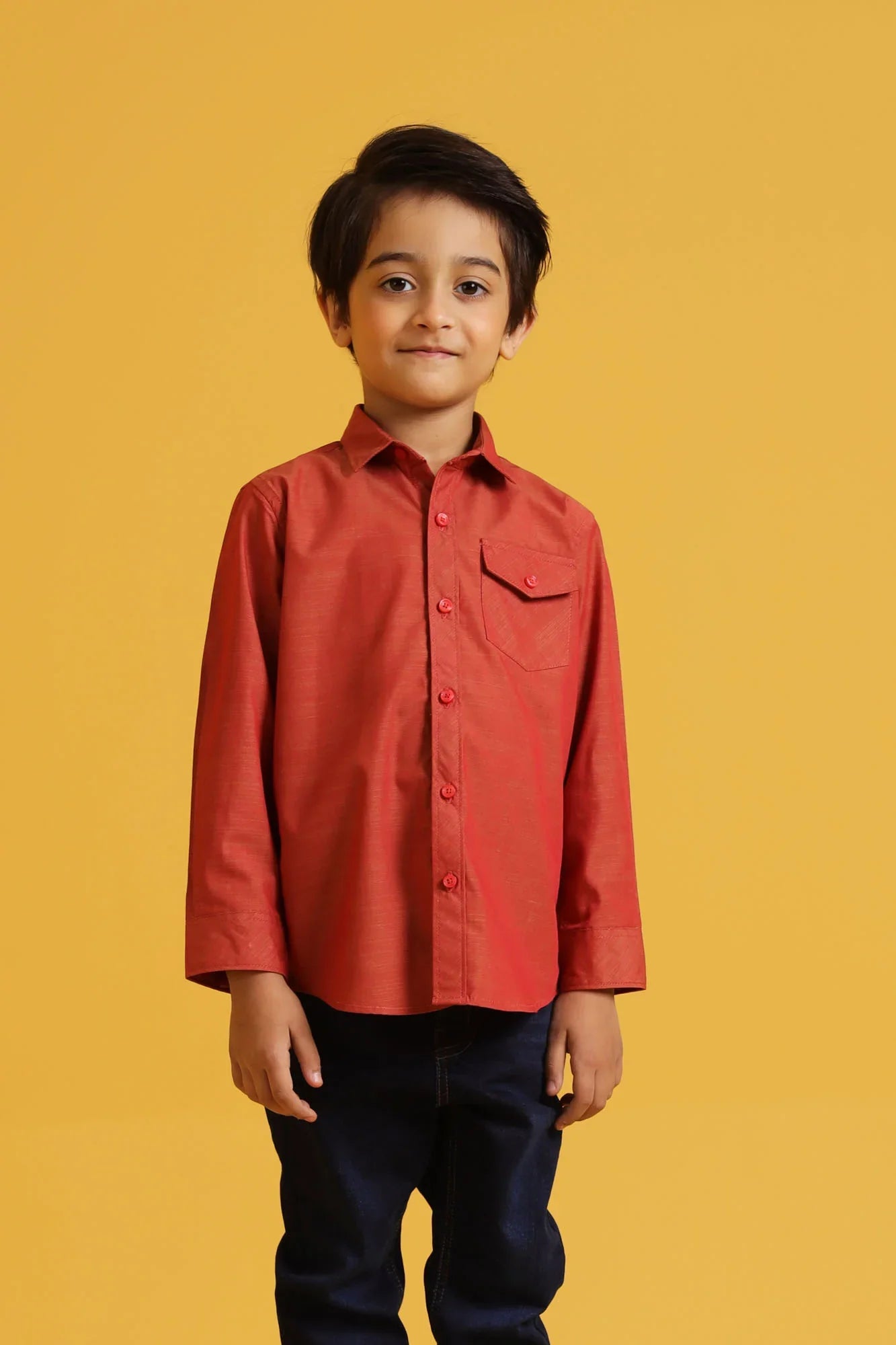 Child wearing a red shirt against a yellow background