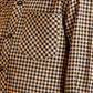 Close-up of a checkered shirt with a pocket on a yellow background