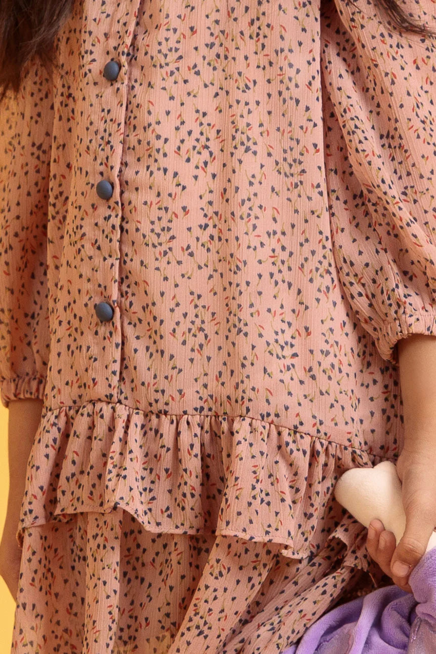 Close-up of a person wearing a pink floral dress with buttons