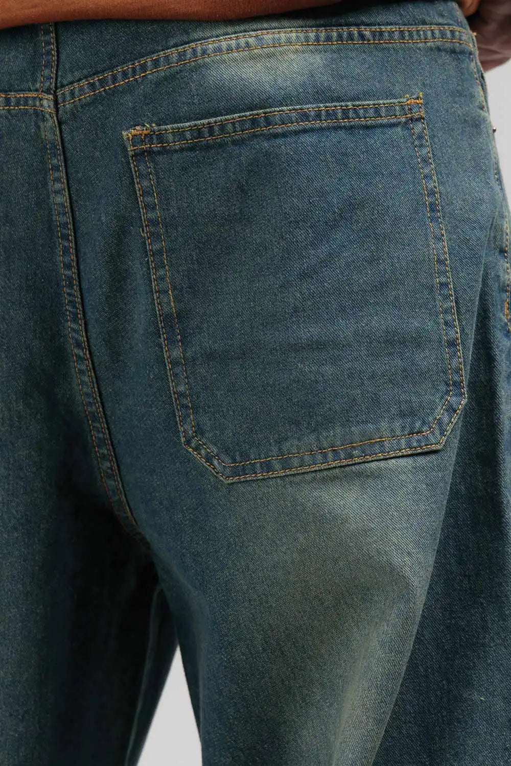 Close-up of blue jeans with a pocket on a plain background