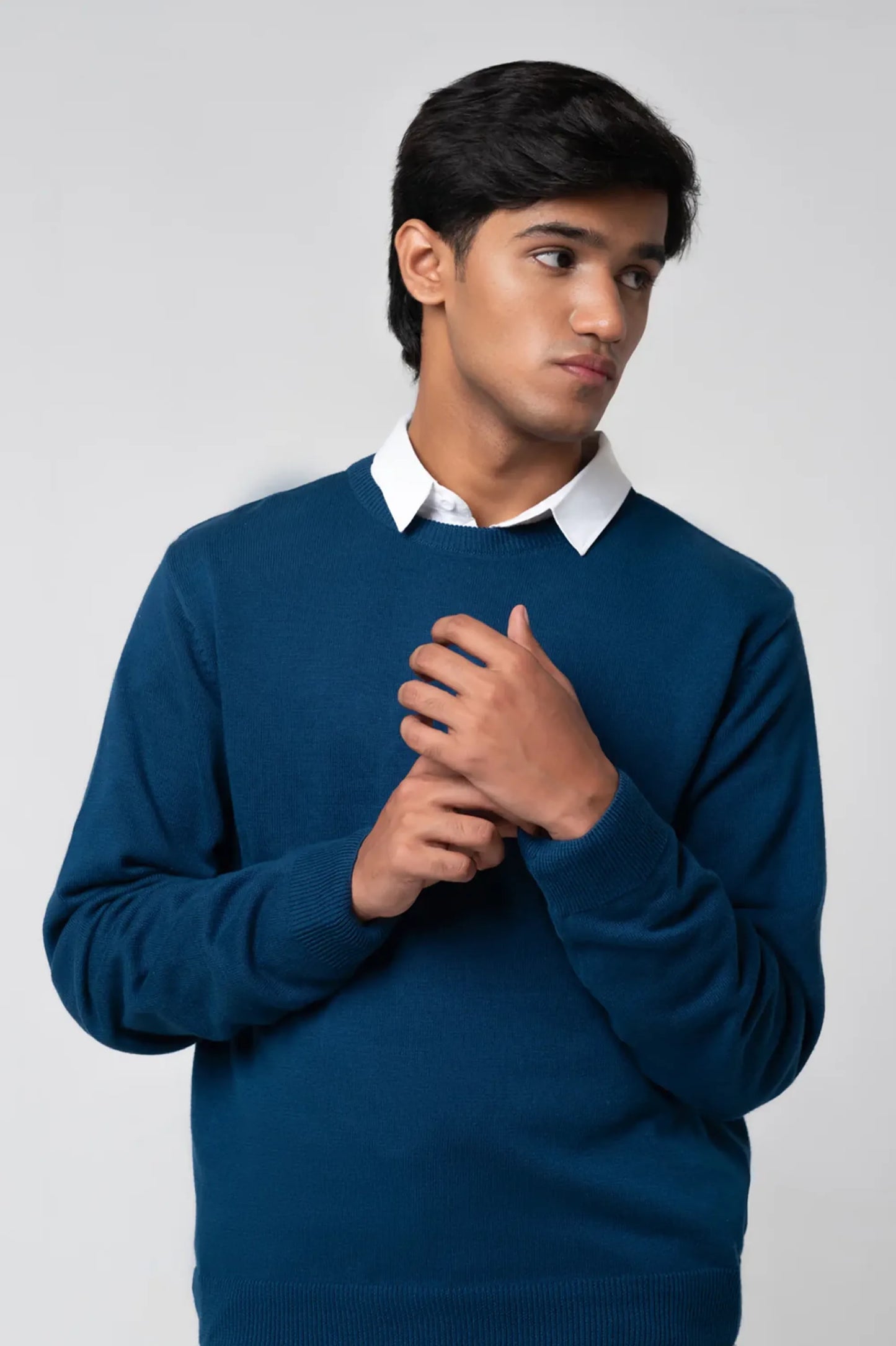 Front pose wearing crew neck sweater navy with layered shirt