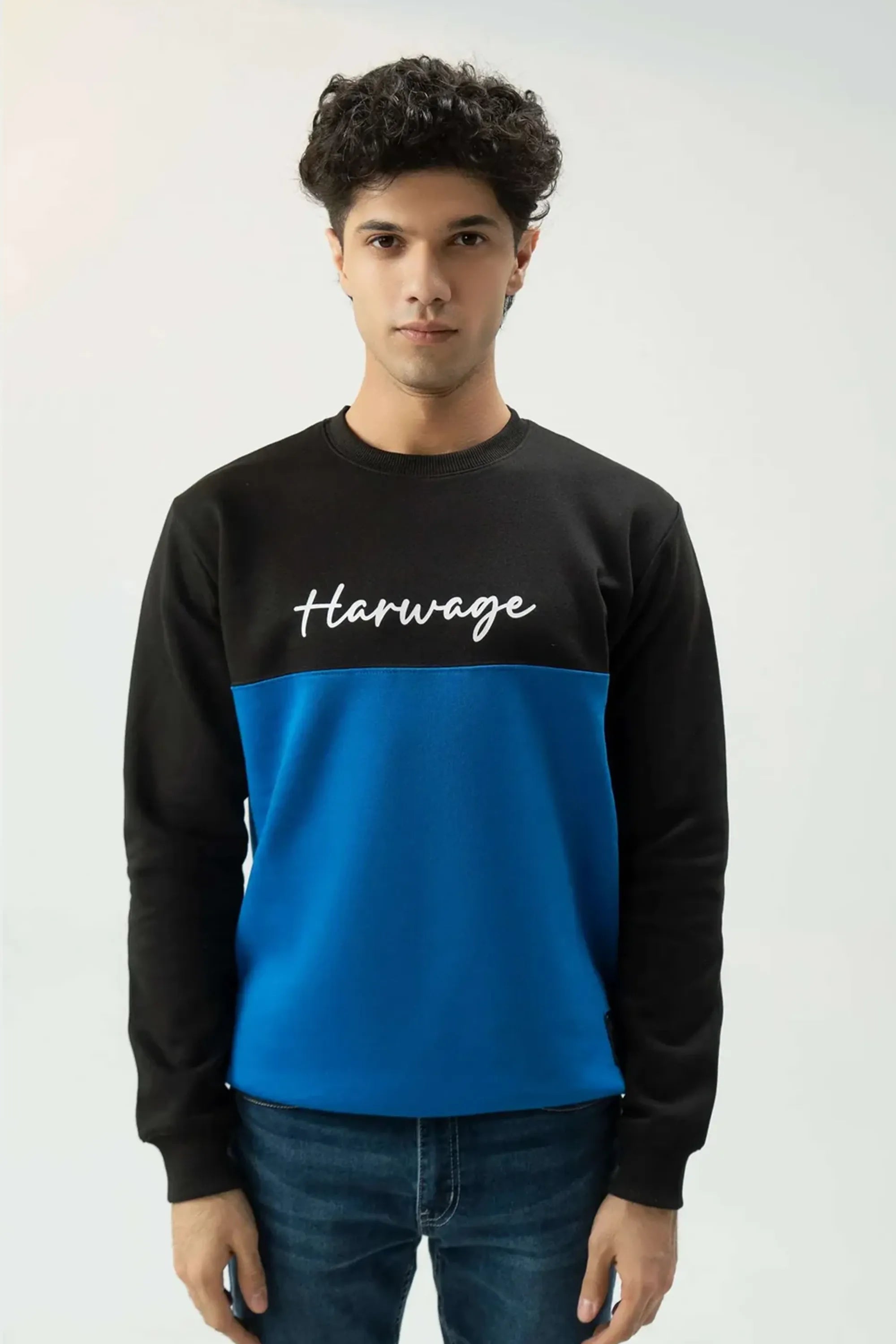 Direct front portrait wearing blue sweatshirt with signature logo