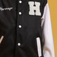 Focused view of black varsity jacket front buttons and chest patch
