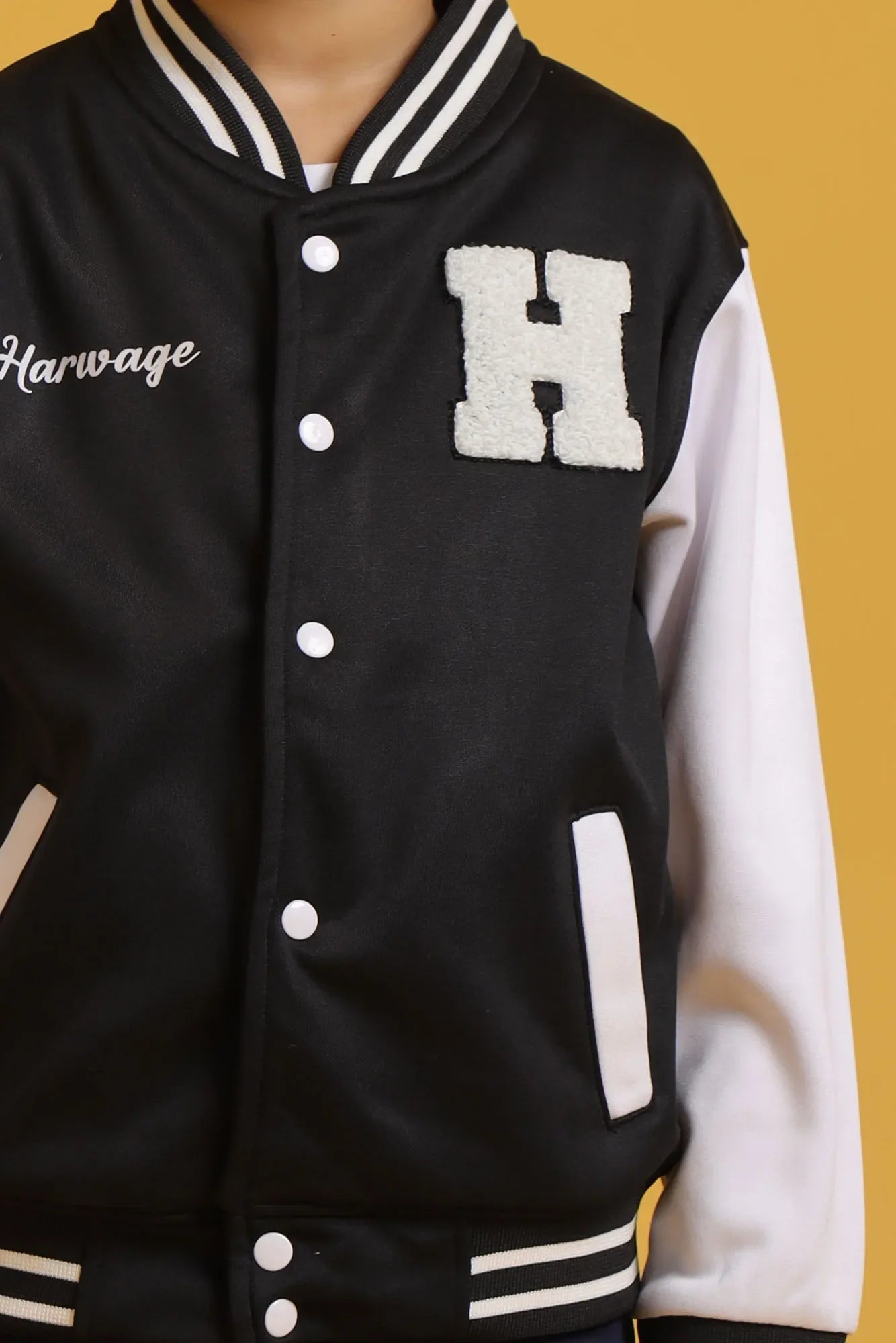 Focused view of black varsity jacket front buttons and chest patch