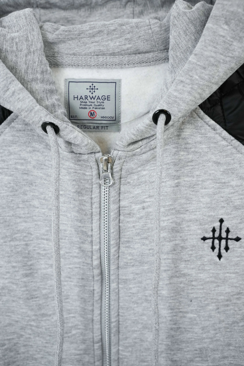 Gray hoodie with Harvage label and black cross emblem on chest