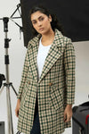 Woman wearing a green and beige checkered coat