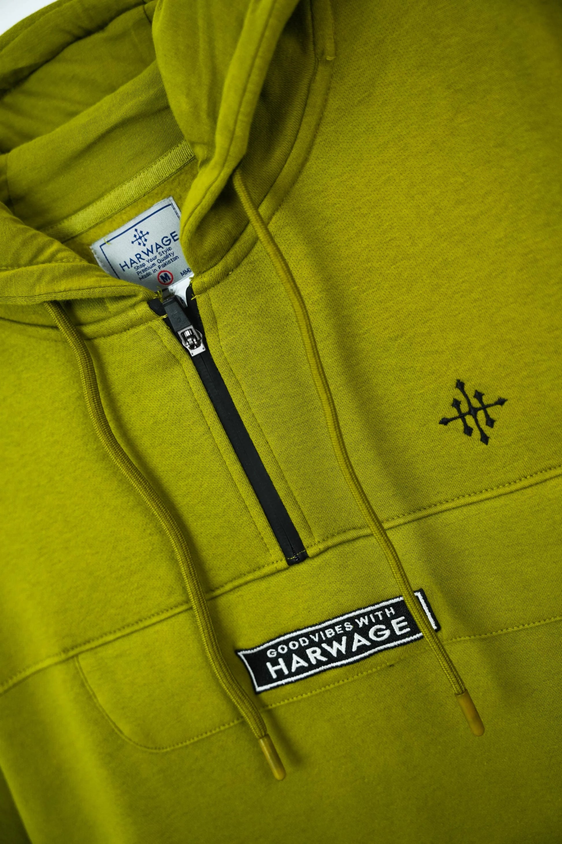Green hoodie with Harwage branding on a close-up of the chest area