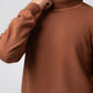 Hand-to-collar close-up showing ribbed neck on brown sweater