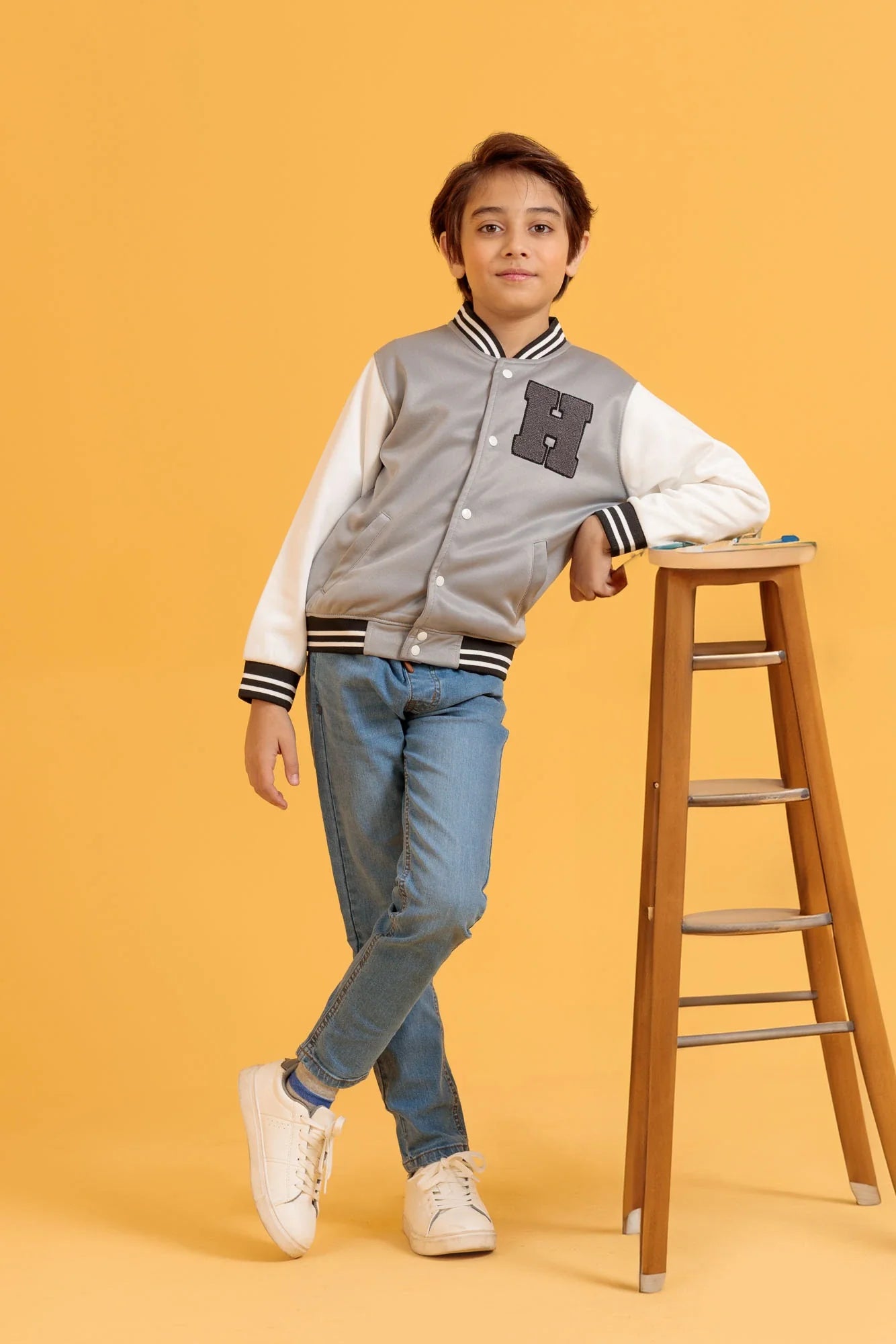 Junior boy wearing a baseball jacket in Wild Dove